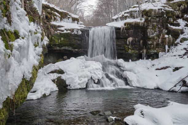 istock Amazing, powerful waterfall covered with snow and icicles during winter season 1314096652