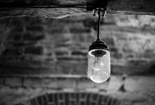 Shot of a lamp in old building in black and white.