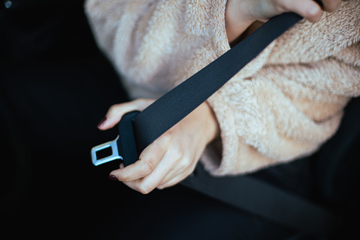 An extremely closeup look at a person's hands tightening the safety belt.
