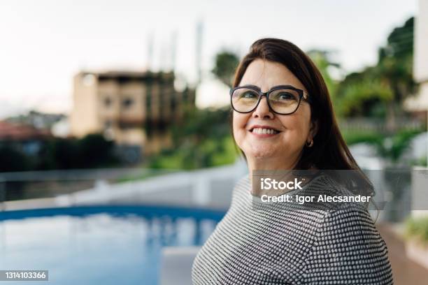 Mature Woman Looking To The Side In Front A Swimming Pool Stock Photo - Download Image Now