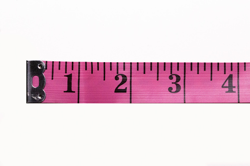 Pink tape measure inches and centimeter isolated in white background