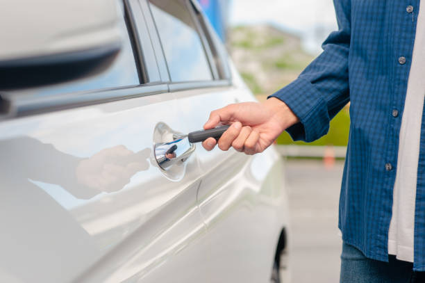 istock Man holding key opening car door 1314136702