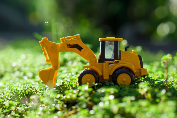 istock Plastic miniature excavators on the green grass 1314140730