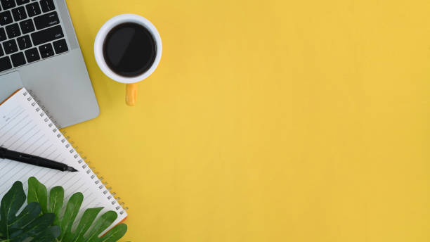 istock Top view of workspace with, computer laptop, notebook, coffee cup and copy space on yellow background. 1314140764
