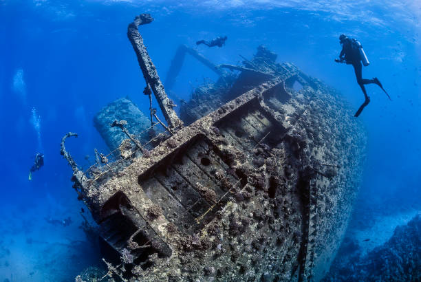 Ghianis D wreck in the Red Sea Divers exploring the outside of a shipwreck scuba diving stock pictures, royalty-free photos & images