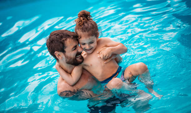 istock Father and son playing together in the swimming pool. 1314146189
