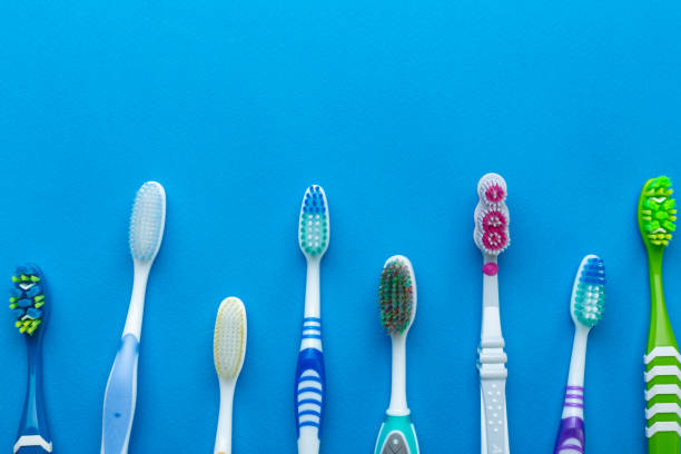 brosse à dents d’isolement dans le fond bleu. - toothbrush plastic multi colored hygiene photos et images de collection