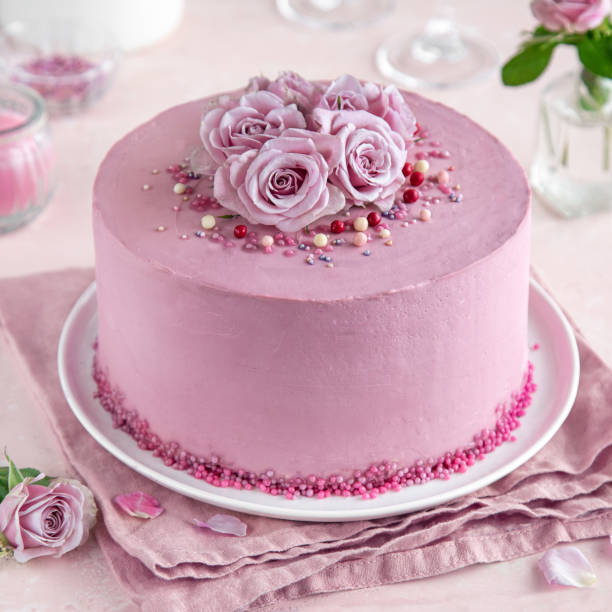 istock festive pink cake on white cake stand decorated with fresh roses 1314150651