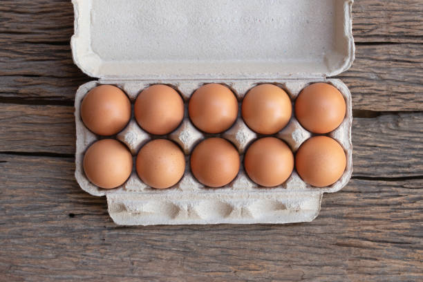 istock Chicken eggs, brown eggs in carton box on wooden rustic table. Top view eggs in carton box. 1314150901