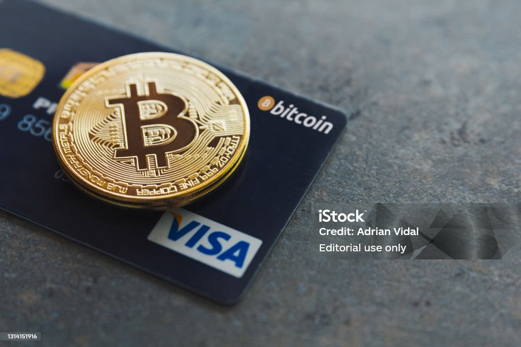 A bitcoin and a Visa credit card on a textured background. Pay with cryptocurrencies wherever you want in more than 40 million places around the world. Bitcoin as new money Valencia, Spain, April 5th 2021: A bitcoin and a Visa credit card on a textured background. Pay with cryptocurrencies wherever you want in more than 40 million places around the world. Bitcoin as new money. Cryptocurrency Stock Photo