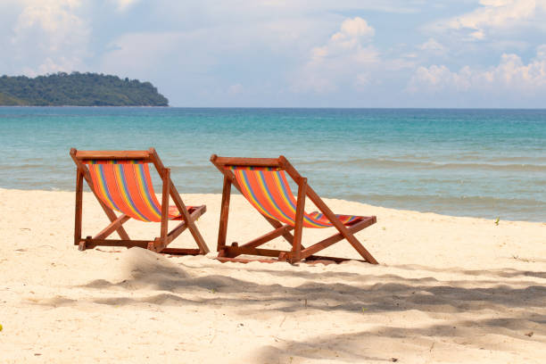 istock Sunbeds, deckchairs on the beach in front of tropical island. 1314152197