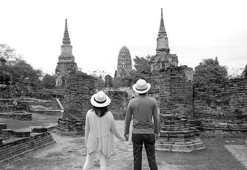 Monochrome image of young couple visiting the amazing temple ruins in the Ayutthaya historical park, central region of Thailand, ( Self Portrait )