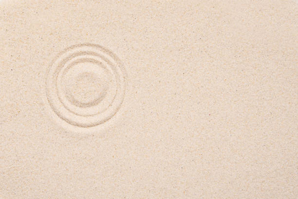 Smooth texture of white sand, top view, layout. Round pattern on sandy background. Concept picture about zen, relaxation, Japanese meditation.