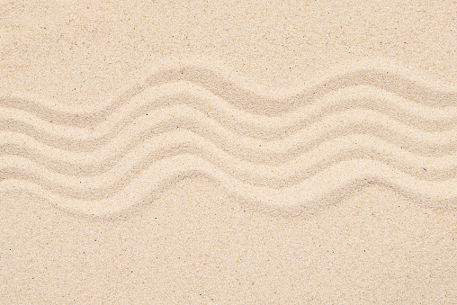 Sandy texture or background, top view of tropical sand with abstract pattern, lines on the sand.