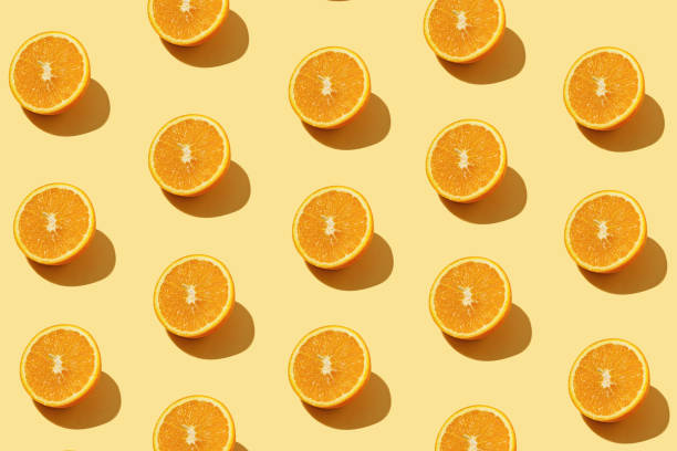 istock Modern pattern with orange slices on yellow background illuminated by bright summer sunlight - Pop art design minimal creative concept - Fresh fruits top view 1314157308