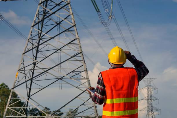 istock A male engineer uses a laptop and is inspecting the construction work. A large electric power pole in front of the construction site. 1314165640