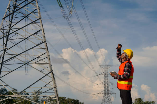 istock A male engineer uses a laptop and is inspecting the construction work. A large electric power pole in front of the construction site. 1314165703
