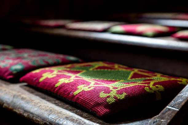 Tapestry Kneelers in a Church Church kneelers on wooden pews, with a shallow depth of field kneelers stock pictures, royalty-free photos & images