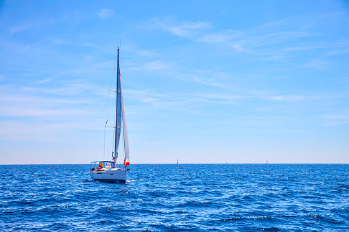 – June 06, 2022: Estepona, Malaga, Spain - June 06, 2022: A solitary catamaran sailing along the Costa del Sol in Malaga