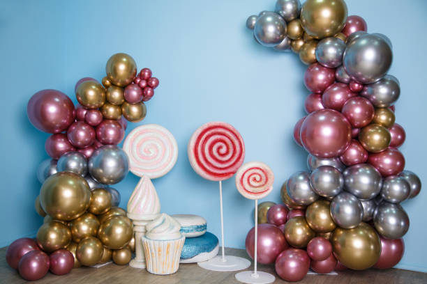 festive decorations on a light blue background. trees made of shiny colorful balloons, huge macaroons, ice cream and caramel on sticks - personal accessory balloon beauty birthday imagens e fotografias de stock