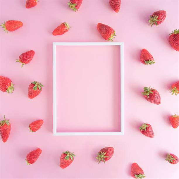 Creative pattern arrangement made of fresh strawberries on a vibrant pink background with white photo frame. Flat lay design. Creative pattern arrangement made of fresh strawberries on a vibrant pink background with white photo frame. Flat lay design. book heart shape valentines day copy space stock pictures, royalty-free photos & images