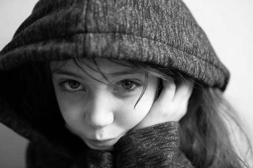 Portrait of a girl 9 years old smiling in a hood isolated