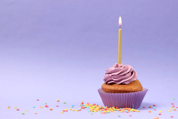istock Delicious cupcake with a candle on a colored background with space for text. 1314174589