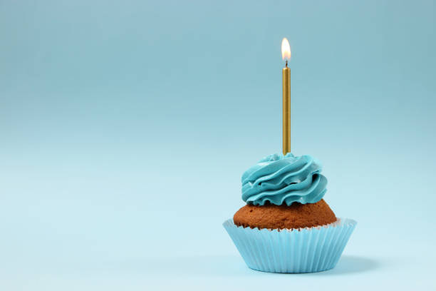 istock Delicious cupcake with a candle on a colored background with space for text. 1314175754