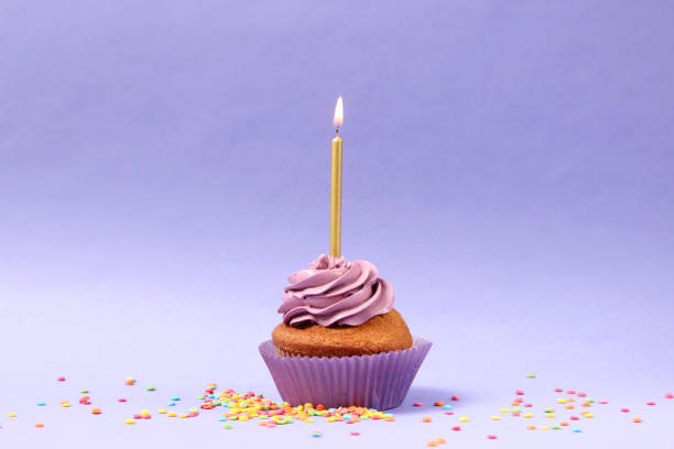 istock Delicious cupcake with a candle on a colored background with space for text. 1314176669