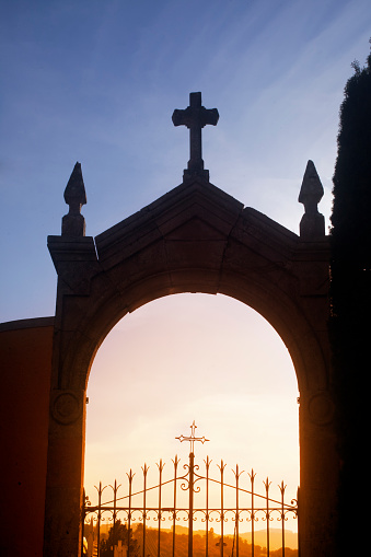 Ancient cemetery gate, monumental  arch and cross at dusk, Sarria village, Lugo province,  Galicia, Spain. Camino de Santiago, camino francés.