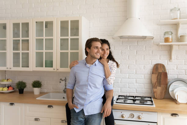 istock Happy dreamy couple hugging, looking to aside, dreaming about future 1314187316