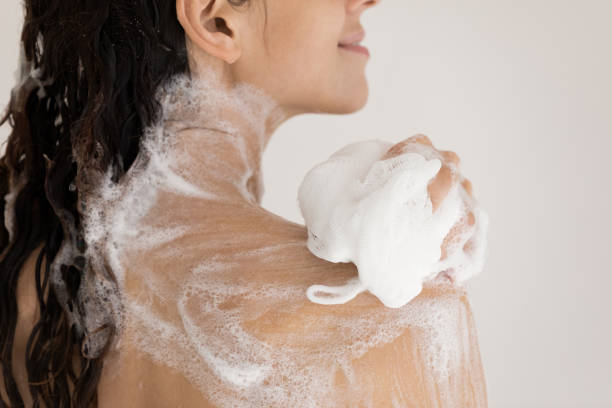 istock Close up woman taking shower with moisturizing soap, using puff 1314187362