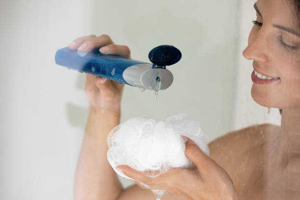 istock Close up smiling woman applying liquid soap gel on puff 1314187367