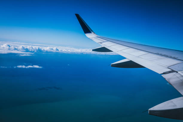 istock Top view from inside window airplane of a blue sky and wing 1314187982