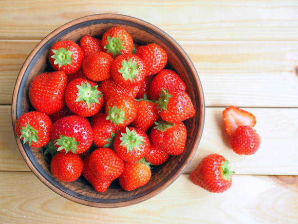 istock Fresh strawberries in a bowl on wooden background 1314189918