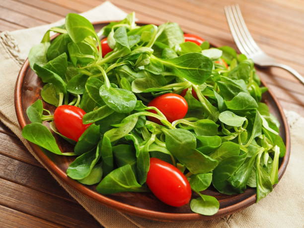 istock Wooden bowl with corn salad, lamb's lettuce and cherry tomatoes 1314190017