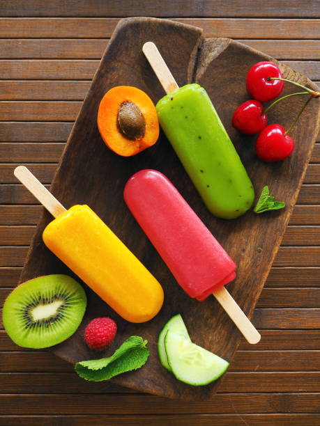 Homemade fruit ice cream - green, red and yellow ones on wooden table
