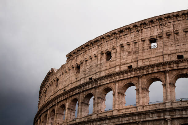 colosseo su sfondo cielo scuro. roma, italia. - ancient past arch natural arch foto e immagini stock