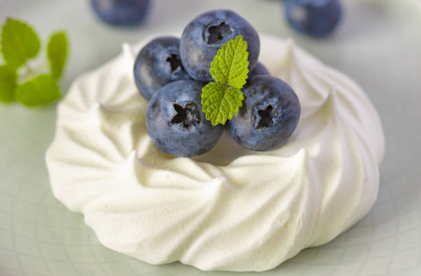 white meringue with blueberries and mint, pavlova dessert with berries