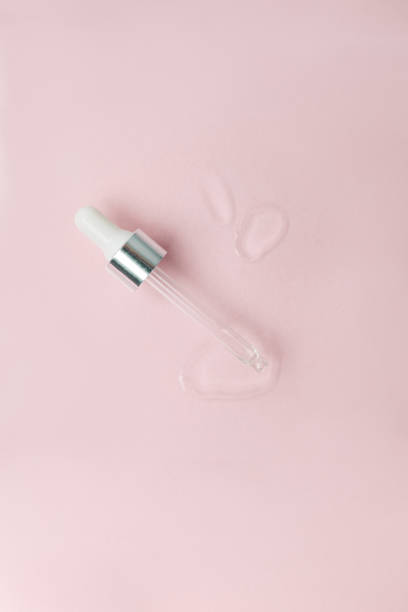 istock Cosmetic pipette with a drop close up on pink pastel background, vertical. Beautician, cosmetology minimal stylish concept, wellness, skincare, face tune, moisturizing treatment 1314199521