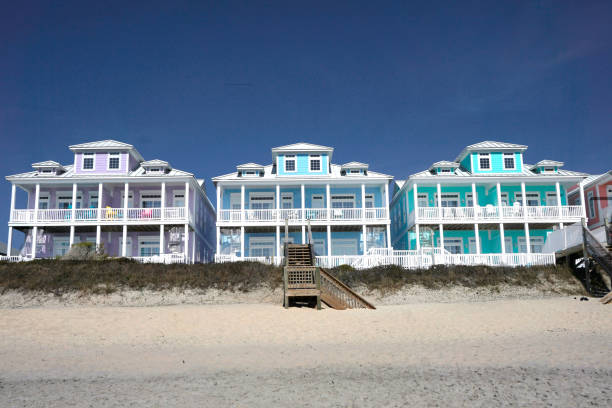 fila de casas multicolores en una playa de arena - coastal property fotografías e imágenes de stock