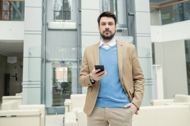 istock Bearded lawyer checking smartphone in lobby 1314203347