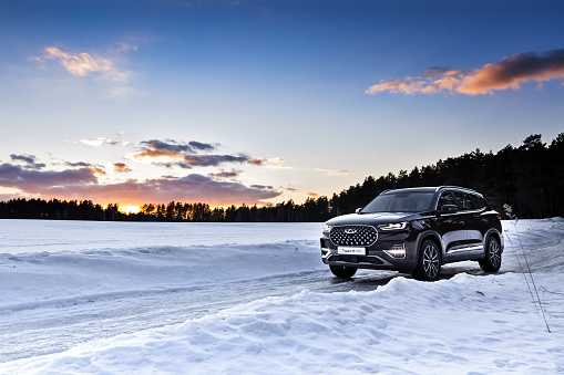 Moscow, Russia - March 19, 2021:  Chery Tiggo 8 Pro \ Plus A purple SUV is parked in the forest. Winter snow. drifts, large Chinese premium car.