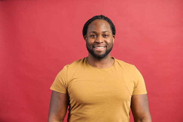 istock Cheerful African-American guy smiles isolated on red 1314205788