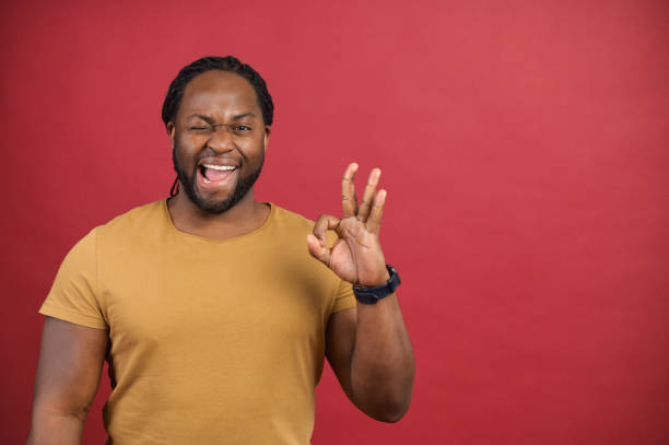 istock Cheerful African-American guy shows okey gesture isolated on red 1314205849