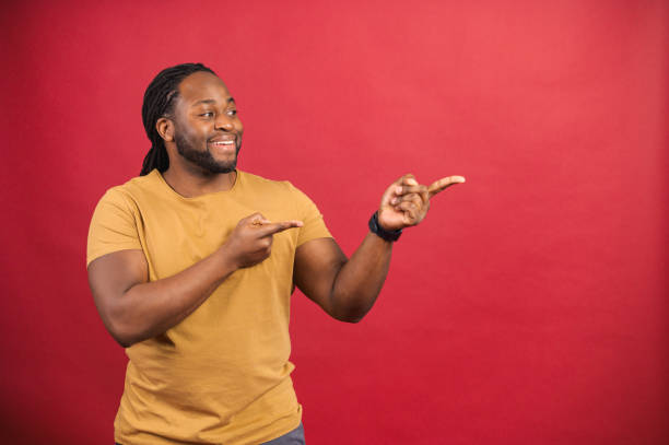 istock Positive black man looks and points to the side with both index fingers 1314205873