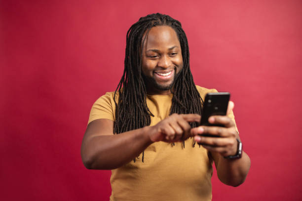 istock Happy dark skinned man looking at the phone screen 1314206975