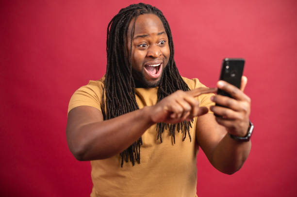 istock Amazed dark skinned man looking at the phone screen 1314207000