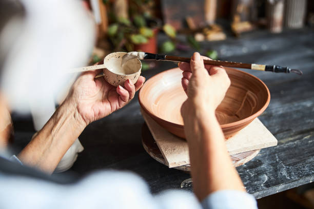 istock Female ceramist painting earthenware in pottery workshop 1314207930