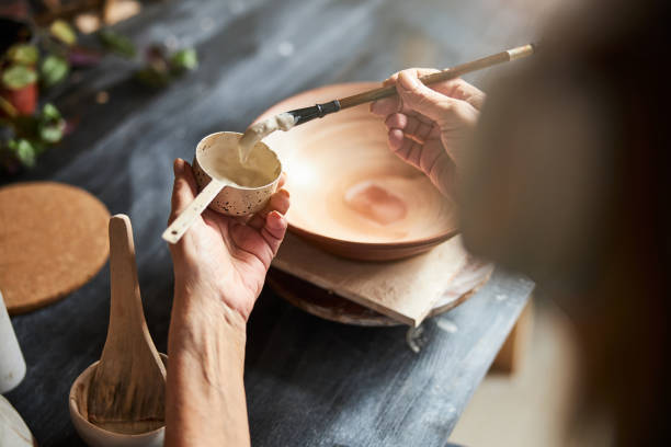 istock Female ceramic artist painting earthenware in pottery workshop 1314207934